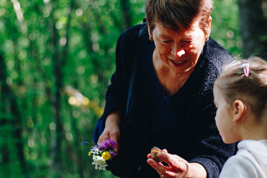 Grandmother interacting with granddaughter outside on a nice day